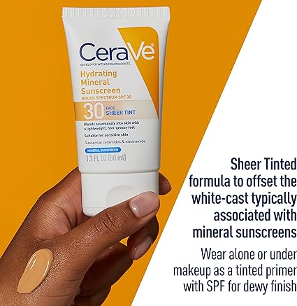 Image of a hand holding a tube of CeraVe Hydrating Mineral Sunscreen SPF 30 with Sheer Tint against an orange background. Next to it is a swatch of the tinted sunscreen. Text on the image highlights the product's sheer tinted formula to offset the white cast typically associated with mineral sunscreens.