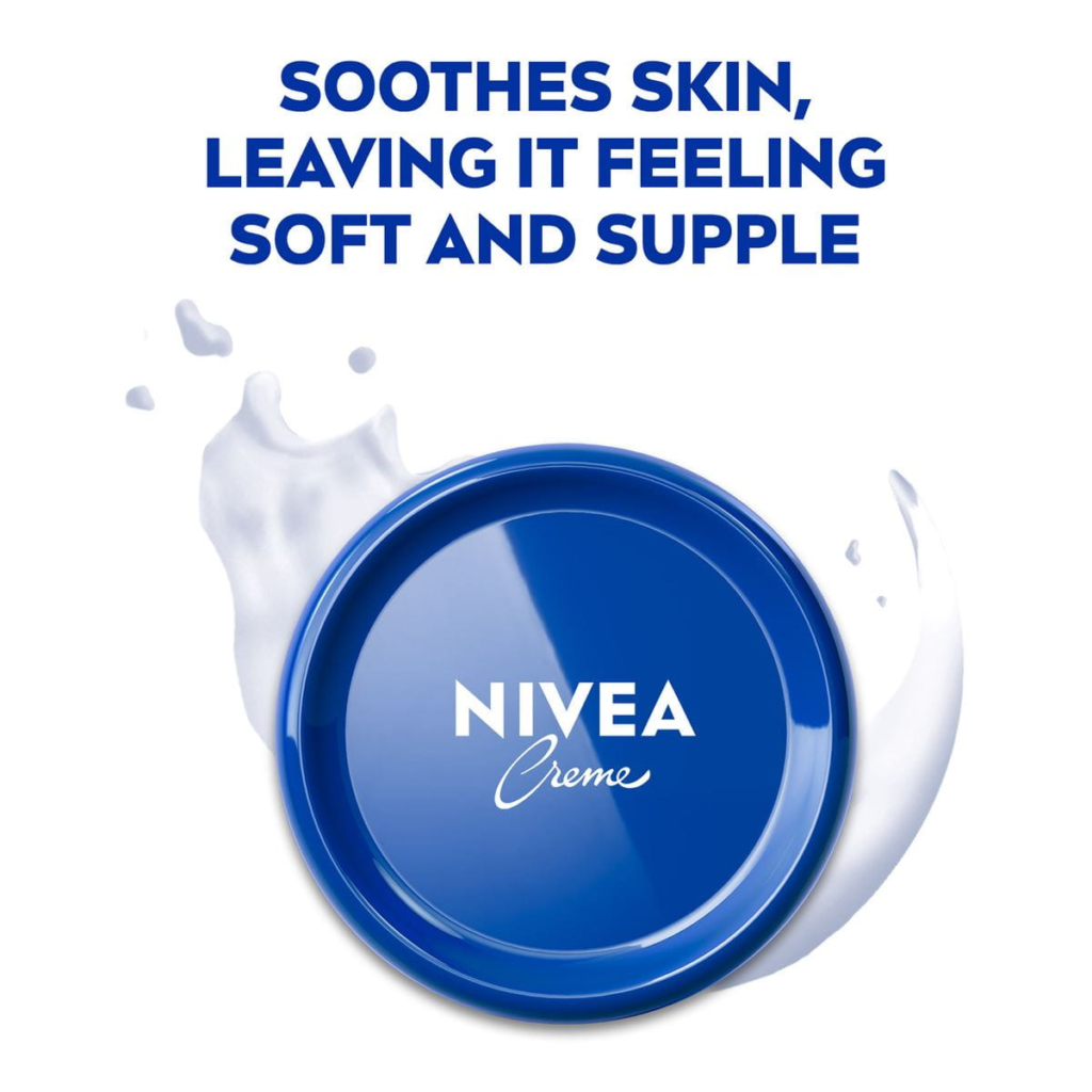 Blue lid of NIVEA Creme with the text 'Soothes Skin, Leaving It Feeling Soft and Supple' above it. The lid is surrounded by a splash of cream.